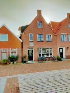 a large brick house with a courtyard in front of it at Noemie's Pension House in Volendam