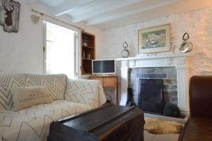 a living room with a couch and a fireplace at Scrumbles Hollow in St. Agnes 
