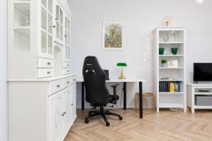 biuro z czarnym krzesłem i biurkiem w obiekcie Amsterdam Estate Apartments Rembrandta w Warszawie