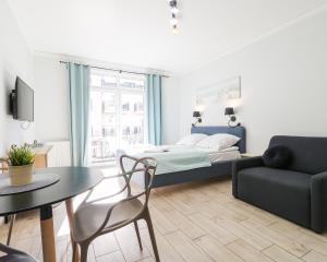 ein Schlafzimmer mit einem Bett, einem Tisch und einer Couch in der Unterkunft Baltic Home in Świnoujście + 37 Fotos