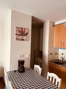 a kitchen with a table with a checkered table cloth at Santiaguiño in Padrón