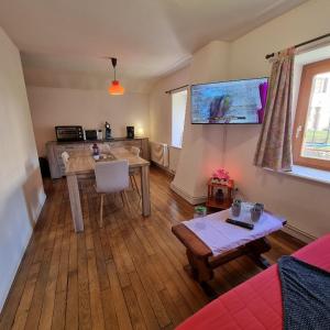 uma sala de estar com uma mesa e uma cozinha em Gite Myrtille 2 à 6 personnes dans Residence des Buis avec Spa em Ventron