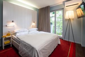 a bedroom with a large white bed and a window at The New Yorker Hotel Köln-Messe in Cologne