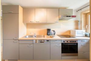 a kitchen with a sink and a microwave at Biohof Vorderreith in Jochberg