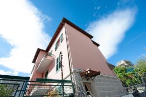 ein rosa Haus mit einem Zaun davor in der Unterkunft Bilocale Cilea con balcone in Varraze