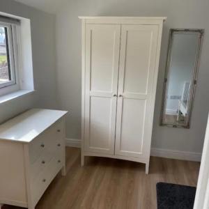Zimmer mit einem weißen Schrank und einem Spiegel in der Unterkunft Haven Oaks - Self Contained Rural Lodge 1 in Shedfield