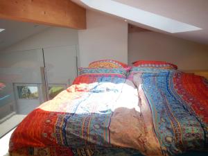 a bed with colorful blankets on it in a room at Retreat im Ostallgäu in Rettenbach am Auerberg