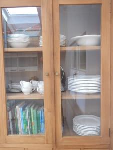 a wooden cabinet with plates and dishes in it at Retreat im Ostallgäu in Rettenbach am Auerberg
