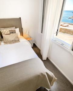 a bedroom with a bed and a window with the ocean at Pino di Loto Boutique Bed & Breakfast in Kinion