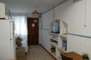 a small room with a kitchen with a refrigerator and a table at CASICA TIA CARMEN in Chulilla +6 photos