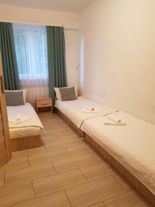 um quarto de hotel com duas camas e uma janela em Hostel Mleczna - Metro Zacisze em Varsóvia