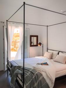 a bedroom with a canopy bed with a book on it at Pino di Loto Boutique Bed & Breakfast in Kinion