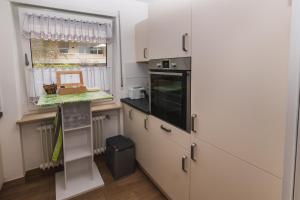 eine Küche mit weißen Schränken und einem Fenster in der Unterkunft Ferienwohnung in dem schönen Kurort Bad Dürkheim in Bad Dürkheim