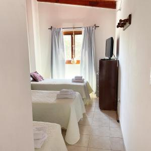 Cette chambre comprend 2 lits et une télévision. dans l'établissement Hotel del Sol Cafayate, à Cafayate