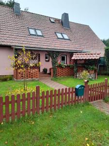 a house with a wooden fence in front of it at Haus Pusteblume in Zahren