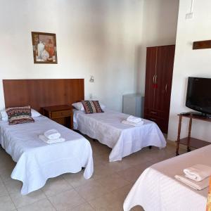 ein Hotelzimmer mit 2 Betten und einem Flachbild-TV in der Unterkunft Hotel del Sol Cafayate in Cafayate