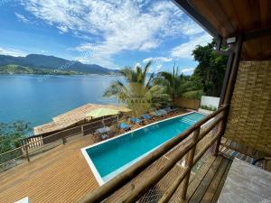 a swimming pool on a deck with a view of a lake at Residencial Solariun Ilhabela in Ilhabela