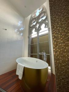 a large bath tub in a bathroom with a window at Martin's Dream Hotel in Mons