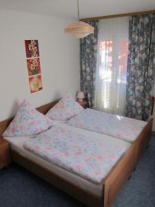 a bedroom with a bed with pink sheets and a window at Gästehaus Maria in Steinach am Brenner