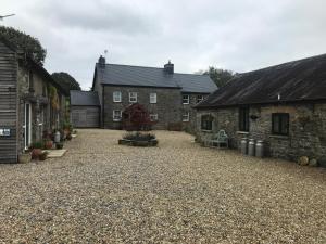 a large gravel driveway in front of two buildings at The Milking Parlour in Llandeilo