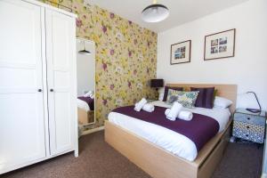 1 dormitorio con 1 cama en una habitación con papel pintado con motivos florales en Cannon Place - Central - by Brighton Holiday Lets, en Brighton & Hove