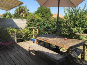 a wooden table and an umbrella on a deck at Le Bayanas in La Rochelle