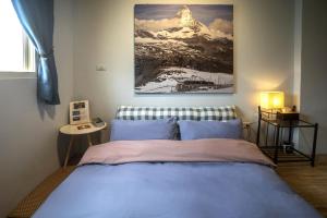 a bedroom with a bed with a snow covered mountain at 123 Cheers Hostel in Hualien City