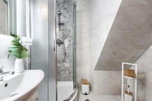 a white bathroom with a shower and a sink at Góralska rezydencja in Witów