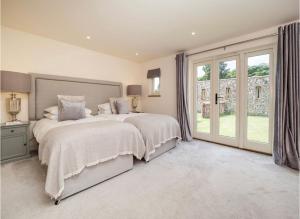 a bedroom with two beds and a large window at Deer View cottage in Salhouse