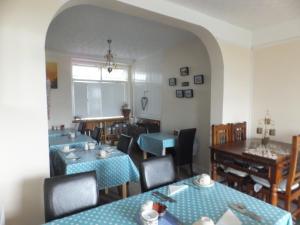 a dining room with blue tables and chairs at Sea Jade Guest House in Bude +27 photos
