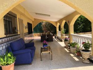 a patio with a blue couch and a table at 4 bedrooms villa with private pool enclosed garden and wifi at Olocau in Olocau