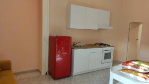 uma cozinha com um frigorífico vermelho e um armário branco em Il cantuccio di Diana em Nápoles