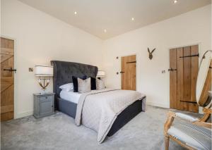 een slaapkamer met een groot bed en een stoel bij Enchanted Cottage in Salhouse