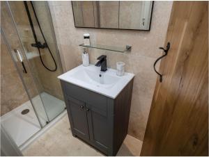 een badkamer met een wastafel en een douche bij Enchanted Cottage in Salhouse