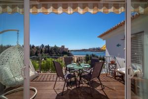a patio with a table and chairs and a view of the water at Front line townhouse Face la mer in Ferragudo luxury sea views in Ferragudo