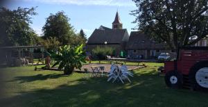 a yard with tables and chairs in front of a church at Gîte Spa Sauna Piscine CÔTÉ VERGER Merxheim Alsace in Merxheim