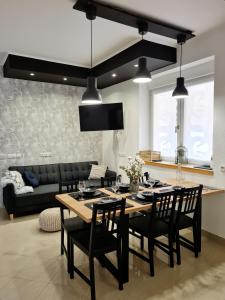 uma sala de estar com uma mesa e cadeiras e um sofá em Kuća za odmor Primavera em Vinkovci