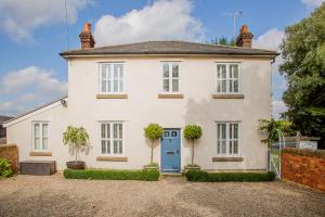 a white house with a blue door at SmallBrook Cottage in Broadway