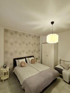 een slaapkamer met een groot bed en een hanglamp bij Kuća za odmor Primavera in Vinkovci