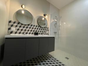 a bathroom with a shower and two mirrors on the wall at Legend - Parking privé - Gare - Centre ville - Quai de Saône - fibre in Mâcon