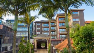 a building with palm trees in front of it at Munyonyo Heights Apartments in Kampala