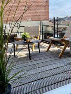 Un patio con dos sillas y una mesa en un tejado. en escapade_Binchoise, en Binche