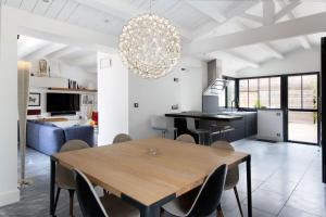 een keuken en eetkamer met een houten tafel en stoelen bij Maison Le Clos Neraud avec piscine et SPA in Saint-Martin-de-Ré