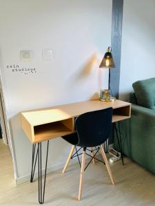 a desk with a chair and a lamp on it at le Seize B in Épernay