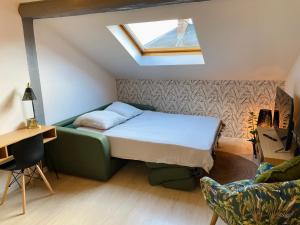 een kleine slaapkamer met een bed en een dakraam bij le Seize B in Épernay