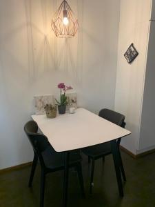 a white table with chairs and a potted plant on it at Modern Apartment with Sauna Nearby Airport in Vantaa