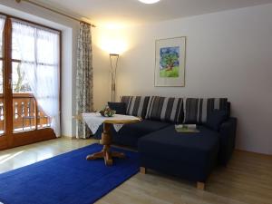 a living room with a blue couch and a table at Ferienwohnungen Auhaus in Bad Reichenhall