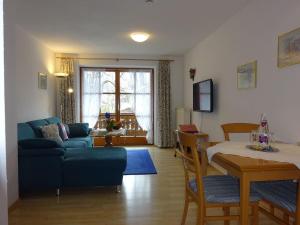 ein Wohnzimmer mit einem blauen Sofa und einem Tisch in der Unterkunft Ferienwohnungen Auhaus in Bad Reichenhall