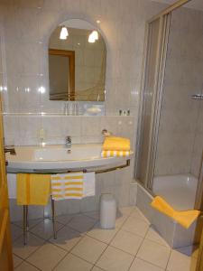 a bathroom with a sink and a tub and a mirror at Ferienwohnungen Auhaus in Bad Reichenhall