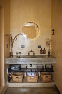 a bathroom with a sink and a mirror and baskets at Botånica Tulum in Tulum